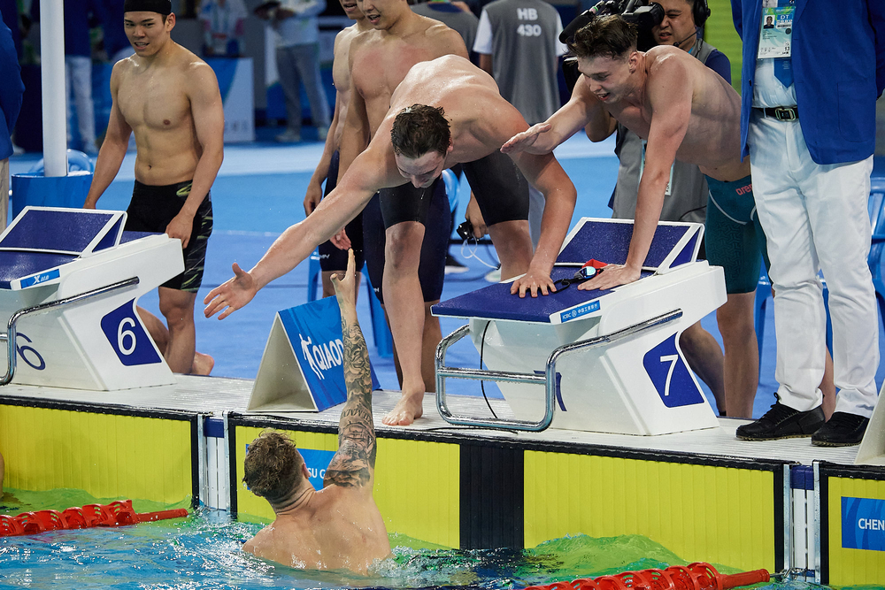 Jakub Kraska, Kamil Sieradzki, Dominik Dudys po zakończeniu wyścigu cieszą się przy basenie